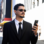 homem, terno escuro, celular, dia de sol, centro da cidade,